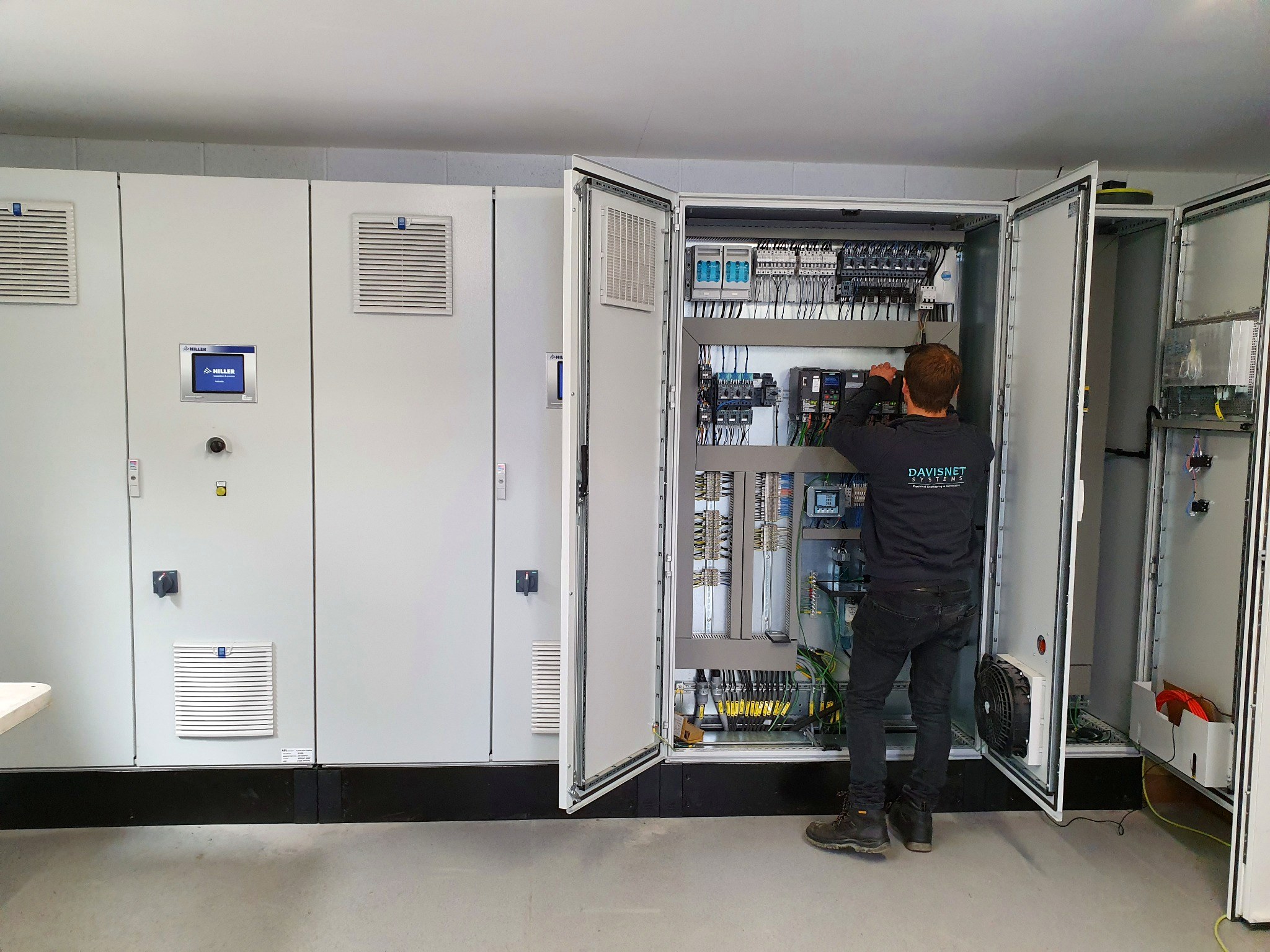 Davisnet engineer working inside an industrial control panel